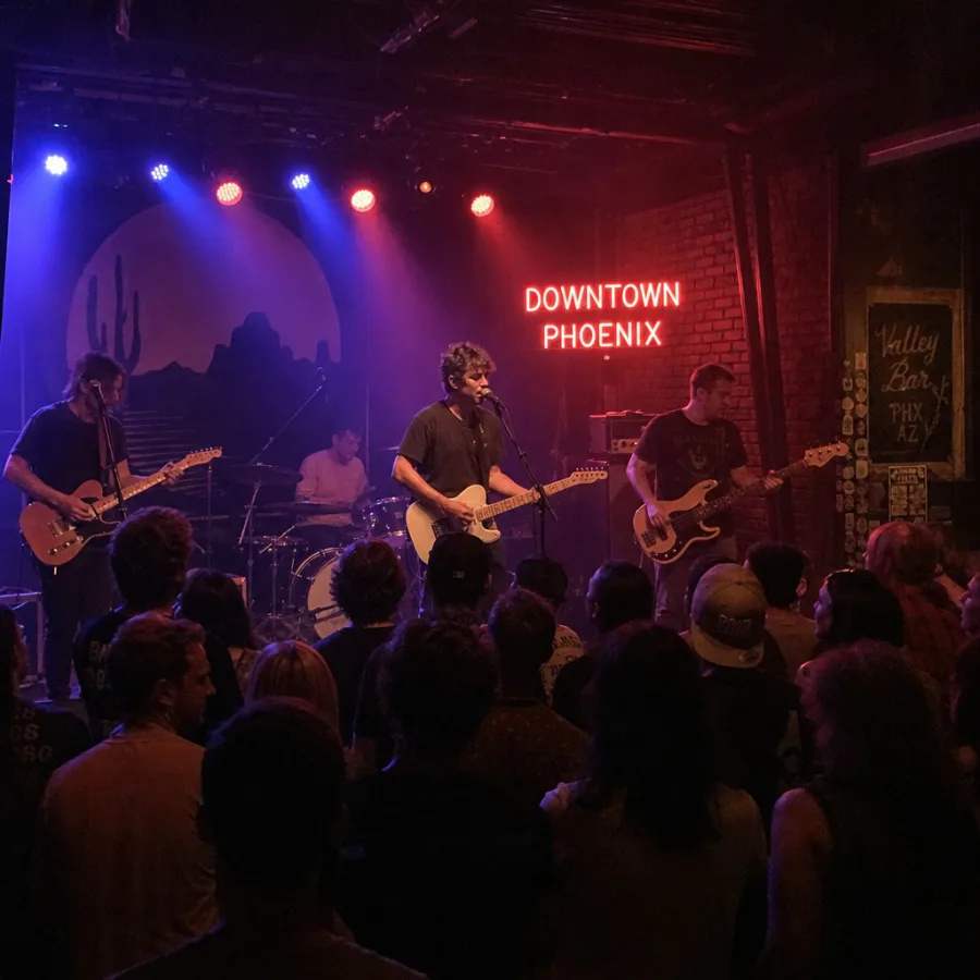 A live band performing on stage under atmospheric lighting at a crowded Downtown Phoenix music venue