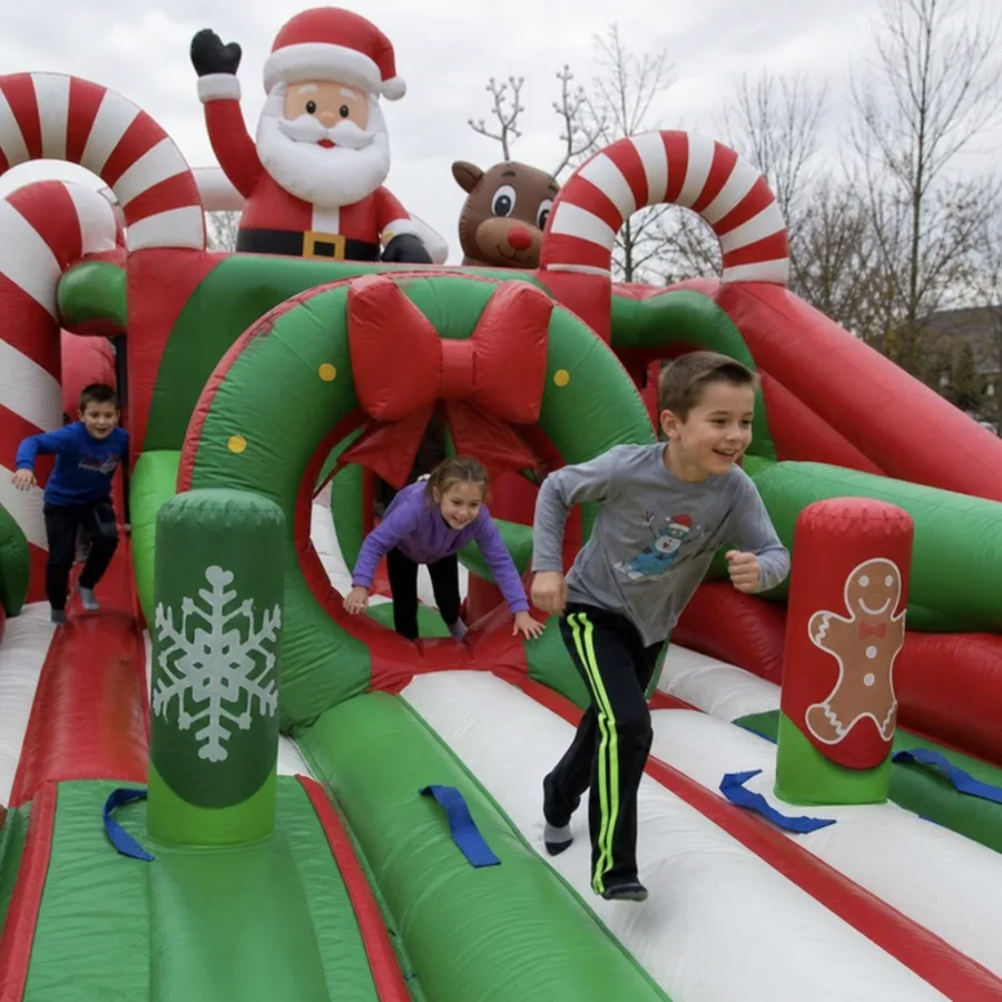 Children racing through a holiday inflatable obstacle course
