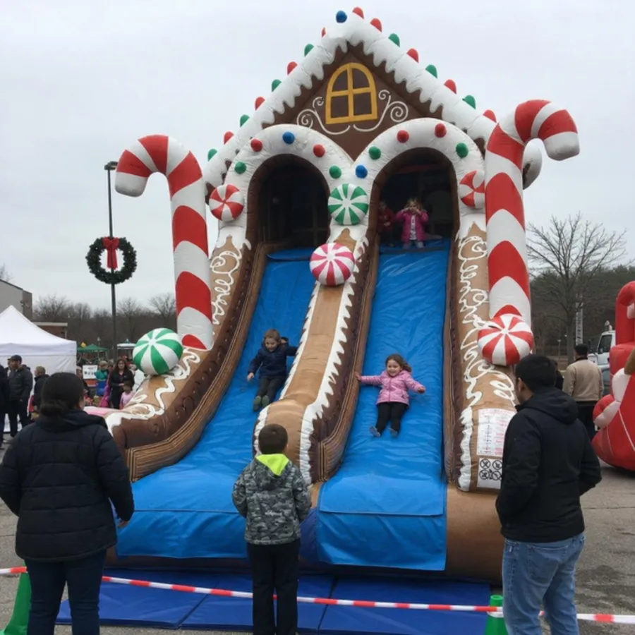Giant gingerbread house dual lane inflatable slide at a holiday event
