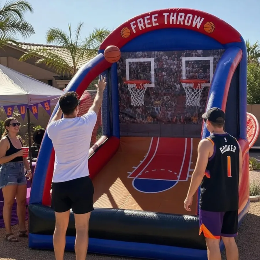 Guests playing an inflatable basketball free throw game at an outdoor Phoenix party