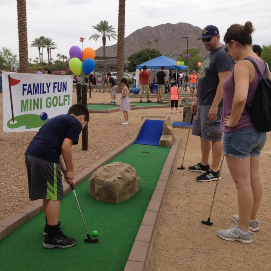 Guests playing outdoor mini golf at a family event in Phoenix