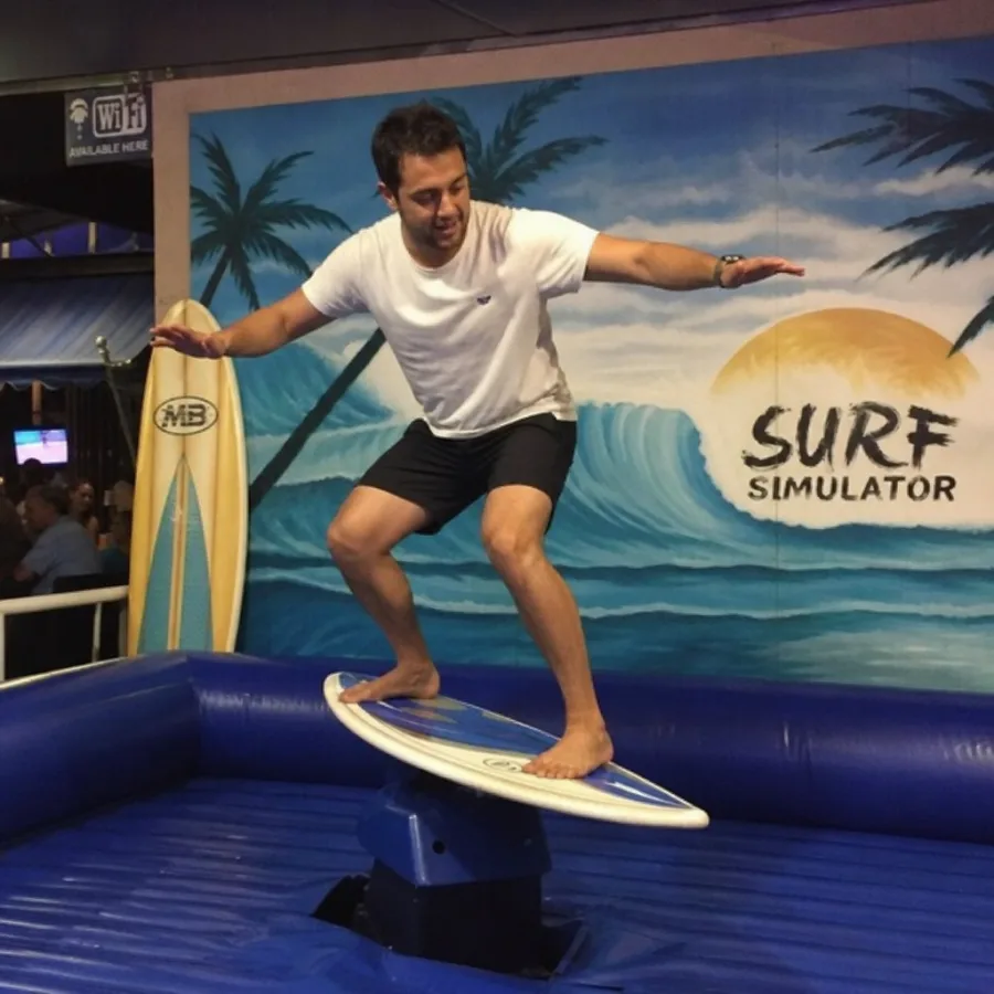Guest balancing on a mechanical surfboard simulator