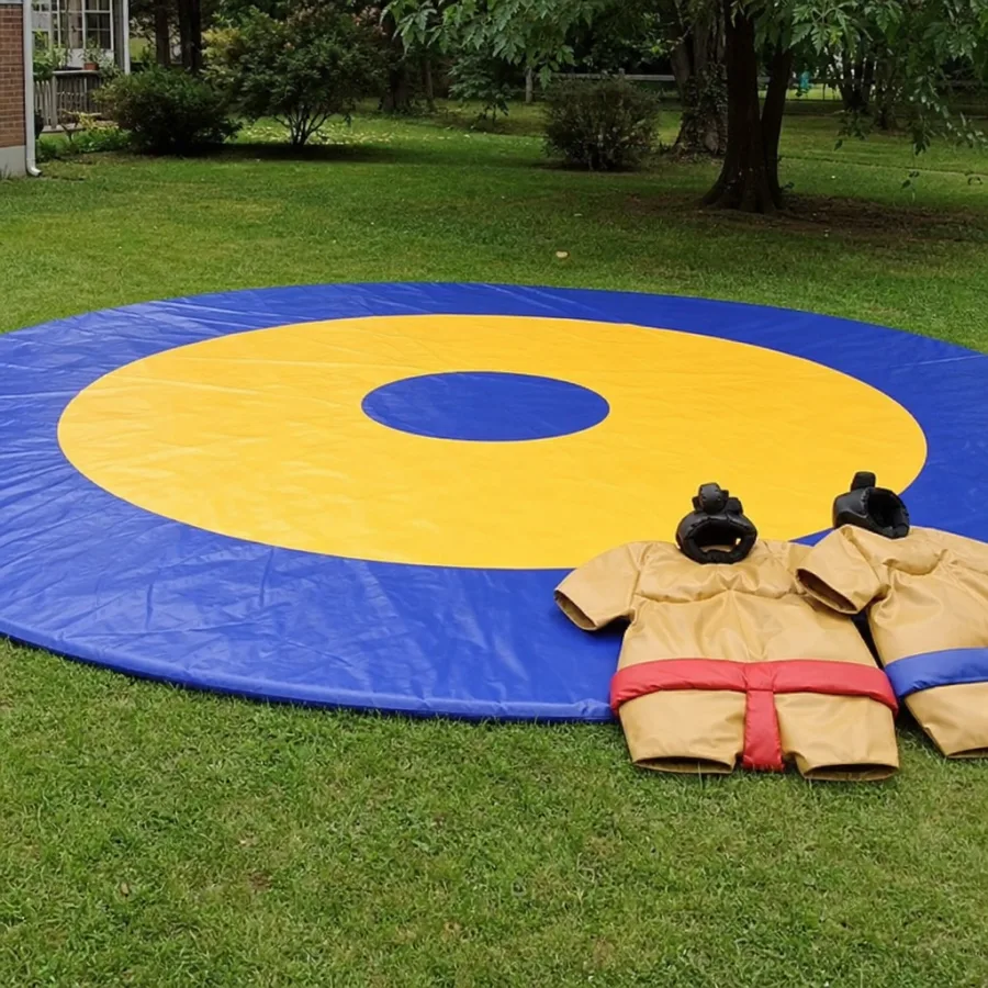 Large heavy duty vinyl wrestling mat set up on a grassy lawn with sumo suits waiting for players