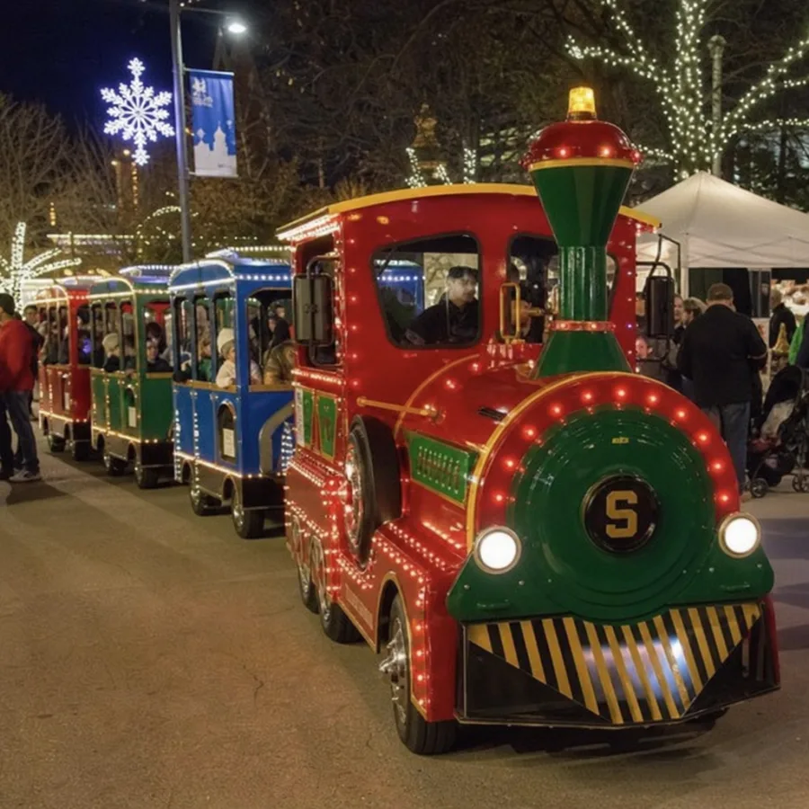 festive electric trackless train at a holiday event
