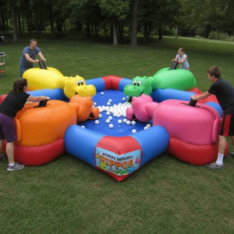Wide shot of a giant inflatable hungry hungry hippos game set up on a green lawn with players competing
