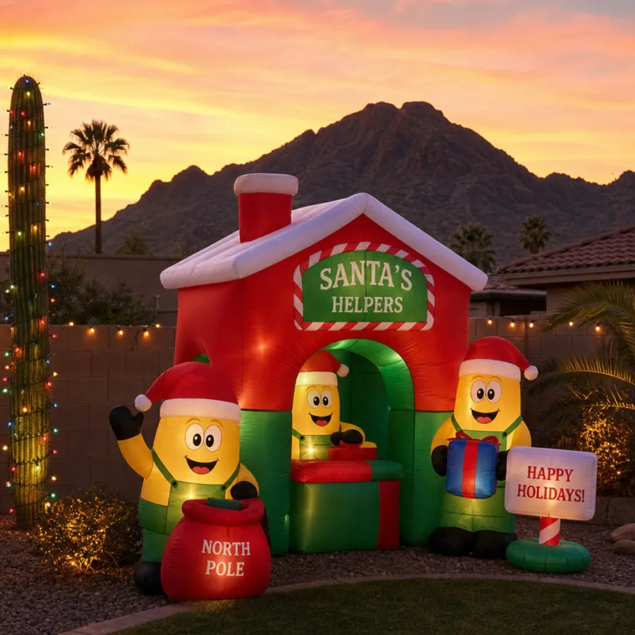 Christmas-themed inflatable with cheerful yellow helper characters in Santa hats in a Phoenix backyard with Camelback Mountain at sunset